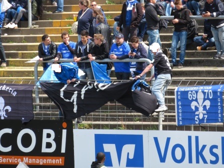 Gemeinsames Zaunschmücken der Griesheimer mit Lilienpower-Darmstadt in der Südkurve. Auch immer schön der Banner vom Fanclub blau-weiß Darmstadt.